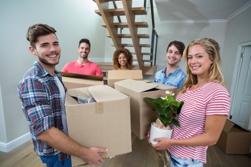 Professional movers carrying furniture through a narrow hallway